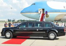 Presidential limousine beside a large blue-and-white jet on a runway
