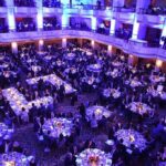 Ballroom filled with round tables at a formal gala dinner