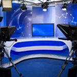 Iran State TV Escalates Threat Against Barron A television studio setup with cameras and a blue backdrop