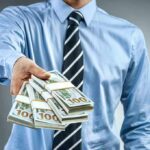 Family Payday Storm Hits Senate Hopeful Person in business attire offering bundles of US dollar bills