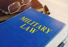 Blue book titled Military Law on a desk