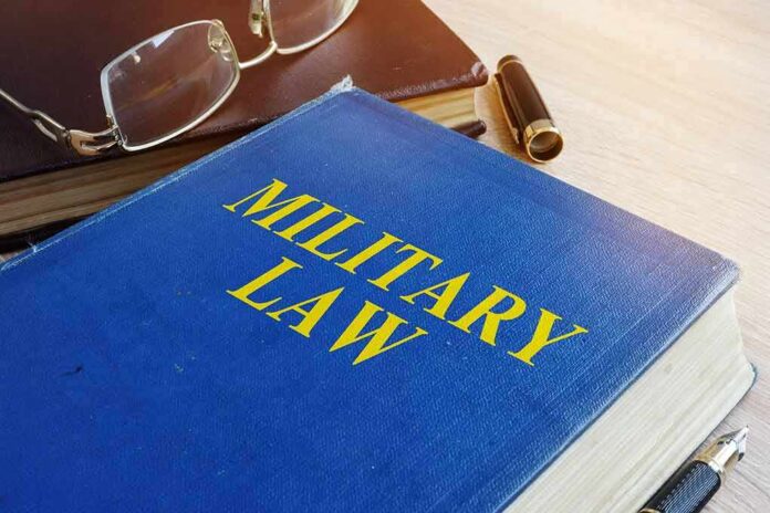shutterstock_1022807239 Blue book titled Military Law on a desk