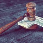 Judge's gavel resting on a stack of US dollar bills