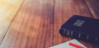 Christian Voters Focus on These 4 Issues Bible and notebook with red pencil on wooden table