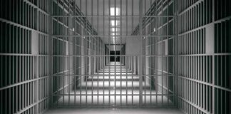 empty prison corridor with barred cells