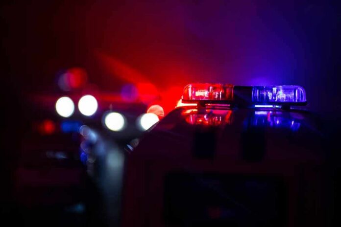shutterstock_1191163906-1 Police car light bar flashing red and blue at night