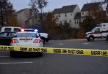 Workplace Threat Explodes Into Gunfire Sheriff's vehicles behind yellow do-not-cross tape