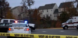 Workplace Threat Explodes Into Gunfire Sheriff's vehicles behind yellow do-not-cross tape