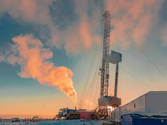 Oil drilling rig at sunset releasing steam