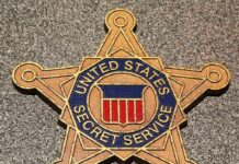 Golden badge of the United States Secret Service displayed on a surface