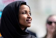 Ilhan Omar in profile wearing a black headscarf outdoors