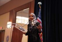 Ilhan Omar speaking at a podium with a microphone