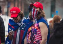 MAGA Buyers Exposed In Subpoenas Group of people at an outdoor gathering; Jerricho Cotchery present among crowd
