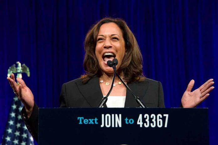 shutterstock_1794703321 Kamala Harris speaking at a podium with arms raised