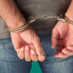person in handcuffs with hands behind back