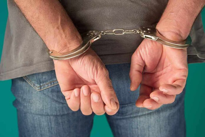 shutterstock_1884015145 person in handcuffs with hands behind back