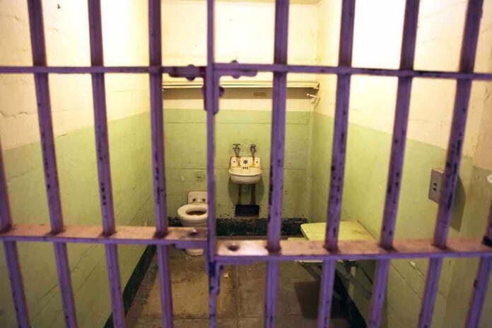 shutterstock_208632826 Interior of a prison cell with a toilet, sink, and metal bars