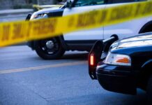 Parking Lot Car Turned Deadly Oven Police cars behind yellow caution tape at a street scene
