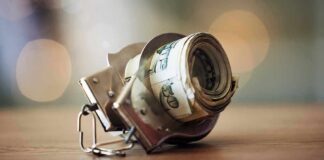 Daylight Beatdown Shocks L.A. Shoppers Handcuffs holding a roll of U.S. dollar bills on a table