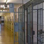 Chaos In Death Chamber Prison corridor with barred doors