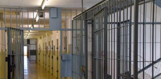 Chaos In Death Chamber Prison corridor with barred doors