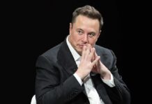 Elon’s Cash Cannon Targets One Race Elon Musk seated in a dark setting with hands steepled near his face