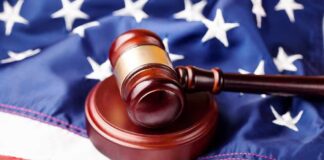 Judge’s gavel on a wooden block over the American flag