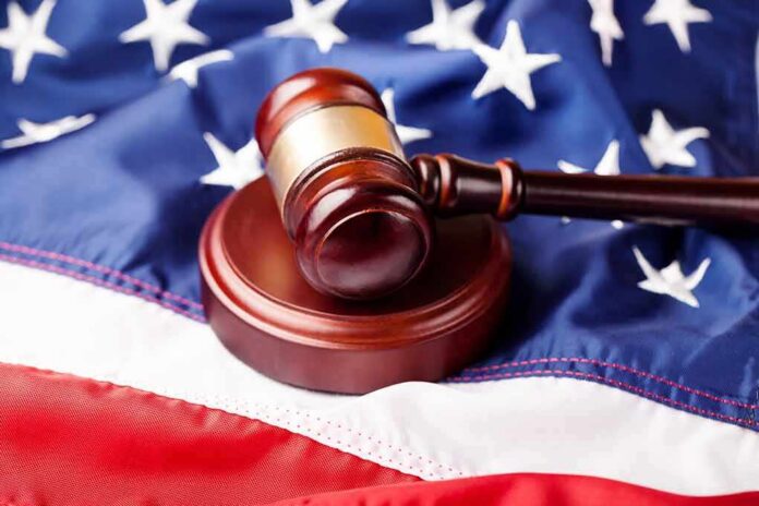 shutterstock_259726991 Judge’s gavel on a wooden block over the American flag