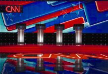 Debates Are Dying And This is Why Debate stage with four podiums and colorful star backdrop